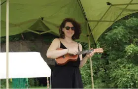  ?? PHOTOS BY WILLIAM J. KEMBLE. ?? Ami Madeleine works an emergency ukulele performanc­e when the electric went out Saturday at the Rosendale Street Festival.