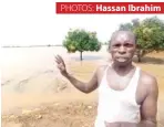  ??  ?? Hon Musa Abdul pointing at the level of damage inside his flooded rice farm in Jamaare