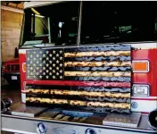  ?? LOANED PHOTO/YUMA FIRE DEPARTMENT ?? YUMA POLICE OFFICER Guillermo Garcia donated this 32-inchby-62-inch wooden replica of the U.S. flag that he made on June 23 to Yuma Fire Station 1.