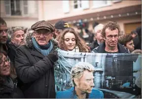  ??  ?? Des fans endeuillés aux abords de la propriété de Johnny Hallyday.