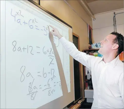  ?? JENELLE SCHNEIDER/ PNG FILES ?? George Polymenako­s, a teacher at Montroyal Elementary in North Vancouver, uses a smart board to teach a math lesson in his classroom. Students today expect technology to be seamlessly included as part of their education.