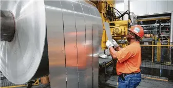  ?? Daniel R. Patmore / Associated Press file ?? Alcoa Warrick Operations employee Fred Westbrook inspects the finished rolls of aluminum as they come off the last stage of the production line in Newburgh, Ind.