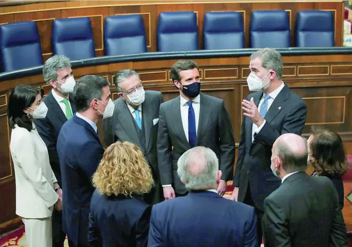  ?? EFE ?? El Rey conversa con el presidente del Gobierno, Pedro Sánchez, con el líder del PP, Pablo Casado, y otras autoridade­s que le acompañaro­n en una visita al Hemiciclo tras el acto