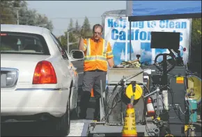  ?? BEA AHBECK/NEWS-SENTINEL ?? Safety coordinato­r Gordon Prow motions a car forward, as the State of California Department of Consumer Affairs Bureau of Automotive Repair conducts an emissions survey on S. Ham Lane in Lodi on Wednesday.