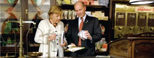  ?? (Reuters / Federico Gambarini) ?? Insieme Karl-erivan Haub con la cancellier­a Angela Merkel mentre visitano il museo della Tengelmann a Mülheim, in una foto d’archivio