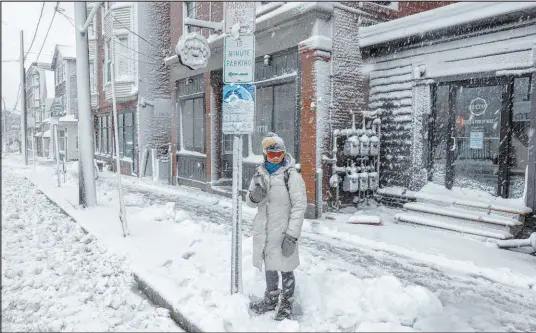  ?? Brianna Soukup The Associated Press ?? Emma Pidden waits for her bus following a spring snowstorm on Thursday in Portland, Maine.