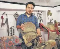  ??  ?? Munshi Aziz Bhat’s great grandson Muzammil Hussain holds an antique horse saddle, Kargil, Jammu and Kashmir