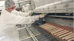  ?? RENÉ JOHNSTON TORONTO STAR FILE PHOTO ?? Gerry Barraba gets the chocolate-pouring machine rolling on the Oh Henry line at the Gladstone Avenue factory, which was purchased by Cadbury in 1996.