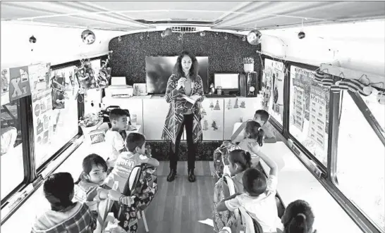  ?? DANIA MAXWELL/LOS ANGELES TIMES PHOTOS ?? Clarissa Ortega leads a class in a converted passenger bus in Tijuana, Mexico. The school is run by a nonprofit that supports children seeking asylum with their families.