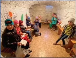  ?? ?? Right: Ukrainian children served by the Ukrainian-based nonprofit Ukrainian Education Platform wait out an air raid at a bomb shelter underneath a Basilian Monastery in Lviv.