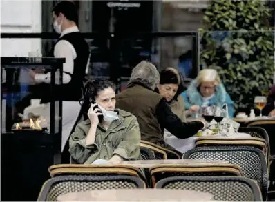  ?? José Luis Roca ?? Una noia parla per telèfon en una terrassa de Madrid, al costat d’altres clients sense mascareta, ahir.