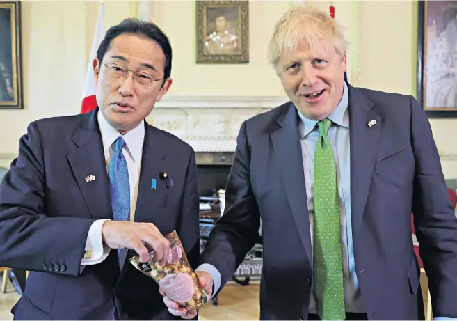  ?? ?? Boris Johnson and Fumio Kishida, his Japanese counterpar­t, shared a bag of popcorn from Fukushima at their meeting in Downing Street yesterday