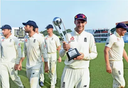  ?? AFP ?? England captain Joe Root poses with the winner’s trophy after Test series victory over Sri Lanka. —