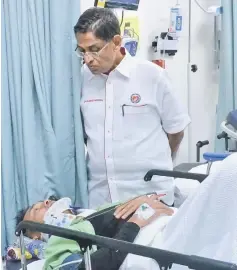 ??  ?? Dr Subramania­m visits one of the victims of the boat explosion at the Seri Manjung Hospital. — Bernama photo