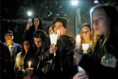  ?? Stephanie Strasburg/Post-Gazette photos ?? Nicole Keating, 44, center, of Ellwood City, wipes a tear from her eye as she gathers with others for a candleligh­t vigil for missing Duquesne University graduate student Dakota Leo James at Katz Plaza in the Cultural District on Monday. Mr. James was...