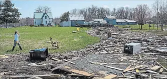  ?? DARREN CALABRESE THE CANADIAN PRESS ?? Michelle Cain looks for belongings in debris from homes and cottages destroyed by the flood water from the Saint John River in Robertson’s Point, N.B., on Sunday.