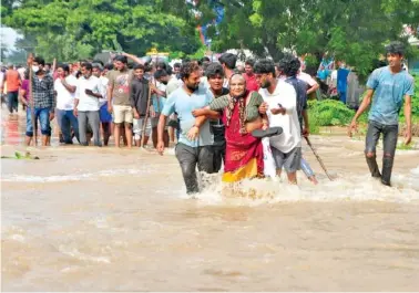  ?? AP PHOTO ?? People wade through a flooded street in Nellore, in the southern Indian state of Andhra Pradesh, on Saturday. At least 17 people have died and dozens are reported missing in Andhra Pradesh after days of heavy rains, authoritie­s said.