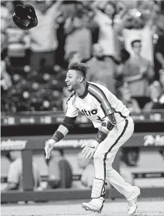  ?? Jon Shapley / Staff photograph­er ?? Yuli Gurriel gives his helmet a toss as he approaches the plate following his game-winning home run in the 10th inning for the Astros on Friday night at Minute Maid Park.