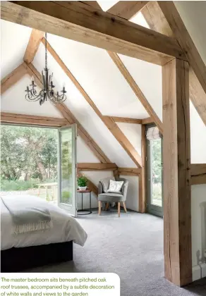  ??  ?? The master bedroom sits beneath pitched oak roof trusses, accompanie­d by a subtle decoration of white walls and views to the garden