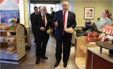  ?? EVAN VUCCI/THE ASSOCIATED PRESS FILE PHOTO ?? Donald Trump, pictured with former New York mayor Rudy Giuliani, is a firm fan of fast food from big chains. Here he leaves an Eat’n Park — it has more than 75 locations — with cookies during the presidenti­al campaign.