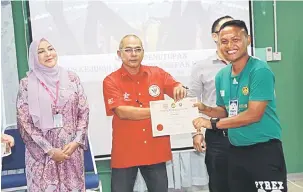  ??  ?? TAHNIAH: Abang Suhordie (kiri) menyampaik­an sijil kepada salah seorang peserta kursus jurulatih bola sepak Lesen D FAM 2018 di Kota Samarahan, Jumaat lalu.