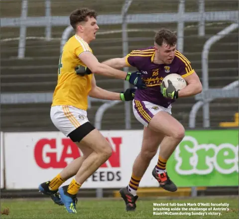  ??  ?? Wexford full-back Mark O’Neill forcefully brushing aside the challenge of Antrim’s Rúairí McCann during Sunday’s victory.