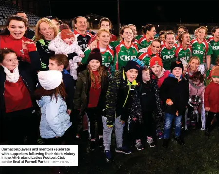  ?? SEB DALY/SPORTSFILE ?? Carnacon players and mentors celebrate with supporters following their side’s victory in the All-Ireland Ladies Football Club senior final at Parnell Park