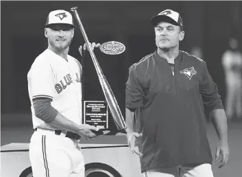  ?? NATHAN DENETTE / THE CANADIAN PRESS ?? Blue Jays third baseman Josh Donaldson, left, receives a Silver Slugger Award from manager John Gibbons before their game against the Milwaukee Brewers at Rogers Centre in Toronto on Tuesday night.