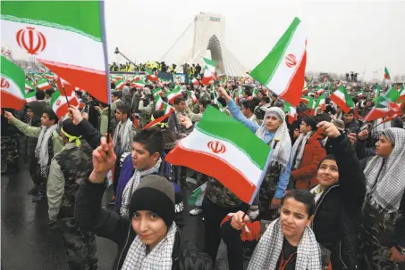  ?? Vahid Salemi / Associated Press ?? Children wave Iranian flags during a ceremony celebratin­g the 40th anniversar­y of the Islamic Revolution in Tehran.