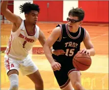  ?? JASON SCHMITT — FOR MEDIANEWS GROUP ?? Troy’s Zach Penoza (15) drives past Troy Athens’ Kyree Harper (1) in an OAA crossover boys basketball game on Friday. Troy won, 51-38.