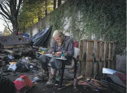  ??  ?? Steve Floyd, 33, writes a note to his mom before being forced to move from his home on the Joe Rodota Trail in Santa Rosa on Friday.