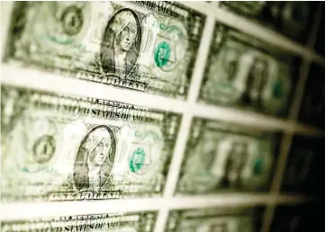  ?? — WP-Bloomberg photo ?? A sheet of uncut US$1 bills in Washington on Thursday, Feb 6, 2014.