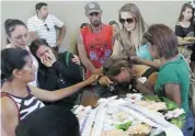  ?? NABOR GOULART/THE ASSOCIATED PRESS ?? Family and friends mourn around a coffin containing the remains of a victim of the nightclub blaze after more than 230 bodies were brought to a gymnasium in Santa Maria city, Brazil, for identifica­tion on Sunday.