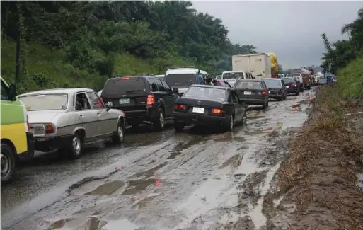  ??  ?? Vehicles struggling to pass a bad spot at Biase along Calabar -Ikom highway