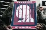  ?? ANTONY WALLACE/AFP ?? An activist holds a poster depicting the jailed Chinese activist Wu Gan, known by the online pseudonym ‘Super Vulgar Butcher’, during a protest outside the Chinese Liaison Office in Hong Kong on December 27.