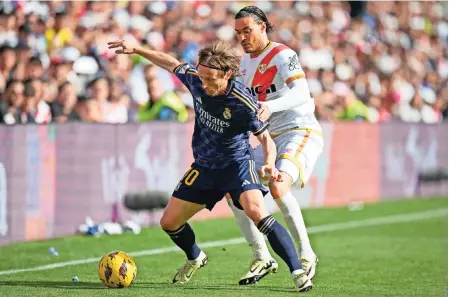  ?? ?? LUKA MODRIC (izq.) cubre el balón de raúl de Tomás del rayo Vallecano