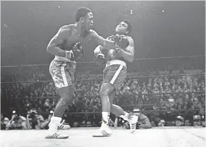  ?? AP ?? Joe Frazier hits Muhammad Ali with a left during the 15th round of their heavyweigh­t title fight on March 8, 1971.