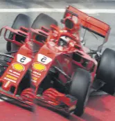  ??  ?? Ferrari’s Sebastian Vettel is reflected in the pitlane during testing.