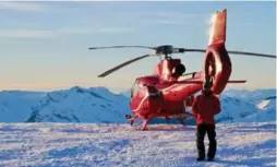  ?? EMMA YARDLEY PHOTOS ?? Helicopter pilot J. Adam Topshee lands on top of Rainbow Mountain.