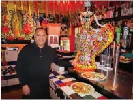  ?? GERARDO ZAVALA — DAILY DEMOCRAT ?? Sal's Tacos manager Hugo Zarate poses next to the restaurant's famous statue of La Catrina, which has become an icon representi­ng the Mexican celebratio­n Day of the Dead.