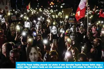  ?? —AFP ?? VALLETTA: People holding placards and photos of slain journalist Daphne Caruana Galizia stage a protest called by Galizia’s family and civic movements on Nov 29, 2019 outside the office of the prime minister.