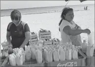  ??  ?? Madre e hija que ayer martes llegaron a Progreso para vender mangos