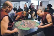  ??  ?? CREATION » Monks from South India create a sand painting Thursday, at the King library in San Jose.