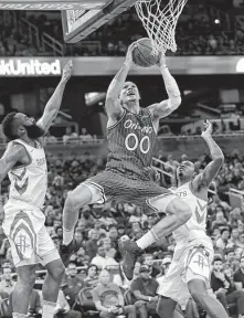  ?? John Raoux / Associated Press ?? Aaron Gordon, center, tied for the Magic’s scoring lead with 22 points on 8-for-15 shooting Sunday in the win over the Rockets.