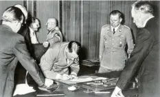  ?? Foto: dpa ?? Adolf Hitler unterzeich­net am 29. September 1938 das Münchner Abkommen. Damit war der Anfang vom Ende der Tschechosl­owakei eingeläute­t.