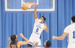  ?? KARL MERTON FERRON/BALTIMORE SUN ?? Mount Carmel’s Toby Nnadozie (2) throws down a one-handed slam dunk during a key matchup against Archbishop Spalding on Friday.