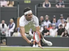 ?? ALASTAIR GRANT/AP ?? TAYLOR FRITZ OF THE US dives to make a return to Australia’s Jason Kubler in a men’s singles fourth round match on day eight of the Wimbledon championsh­ips in London on Monday.