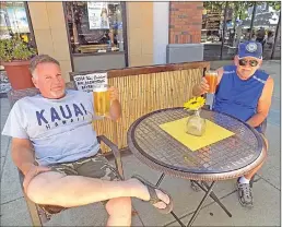  ??  ?? Rodney Averett and Ralph Stevenson enjoy a cold beer at Sopa Thai at the annual Summer Stroll.