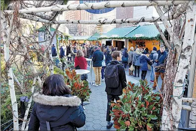  ?? AP/RICHARD DREW ?? Shoppers earlier this month pass through an archway into the Union Square Holiday Market in New York, where vendors offer items from artwork to jewelry.