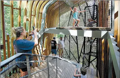  ?? Arkansas Democrat-Gazette/THOMAS METTHE ?? Ellison Brewer, 3, (top) of Springdale poses for a photo for her mother, Sara, during Saturday’s treehouse opening. The structure is designed to inspire children’s interactiv­e learning.